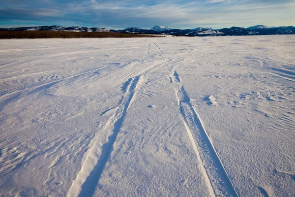 Schneeverwehungen Über Autoreifenspuren Tiefschnee Auf Der Oberfläche Des Zugefrorenen Sees — Stockfoto