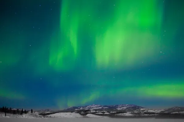 Северное Сияние Aurora Borealis Над Заснеженным Озером Лесистыми Холмами — стоковое фото