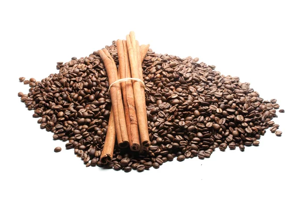 Palitos de canela en un montón de granos de café — Foto de Stock