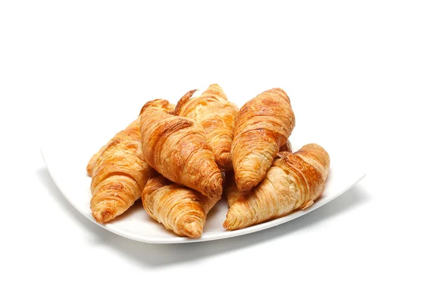 Heap of croissants on white plate — Stock Photo, Image