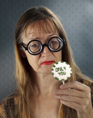 Mid Adult Women with Granny Glasses holding in her Hand Gift/Present Lolly clipart