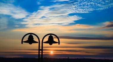 Old lantern at sunset time with nice colored sky at background clipart