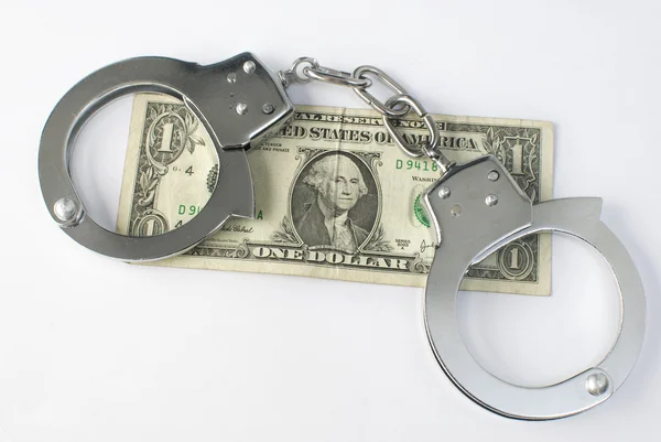 Крупным планом наручники и деньги — стоковое фото