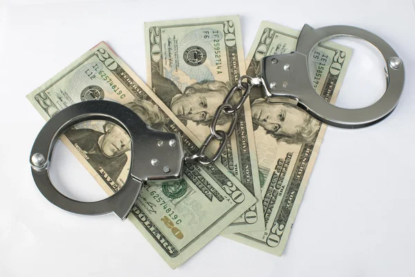 Крупным планом наручники и деньги — стоковое фото