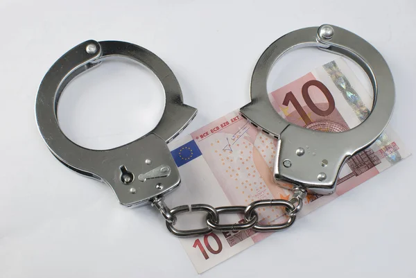 Крупним планом наручники і гроші — стокове фото