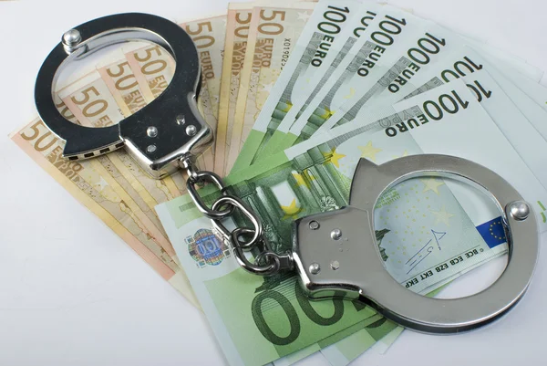 Крупним планом наручники і гроші — стокове фото