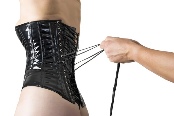 Mains masculines laçant le dos d'un corset . — Photo
