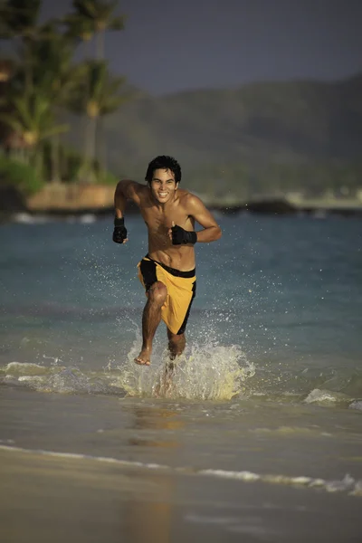 Азиатский мужчина бежит по гавайскому пляжу — стоковое фото