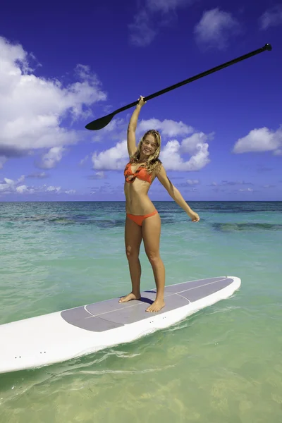 Meisje in een bikini op een bord van de peddel in Hawaï — Stockfoto