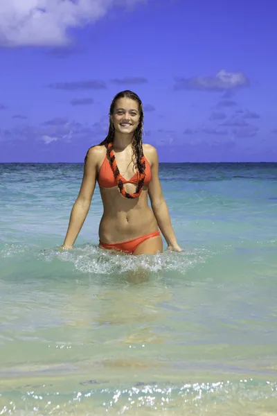 Chica en bikini rojo caminando fuera del océano — Foto de Stock