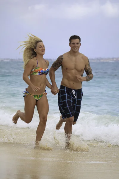 Para biegająca po plaży — Zdjęcie stockowe
