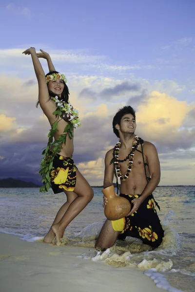 Couple dancing hula by the ocean — ストック写真