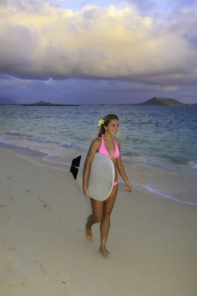少女在粉红色的比基尼女孩与开销作为她行走在夏威夷海滩上的冲浪板 — 图库照片