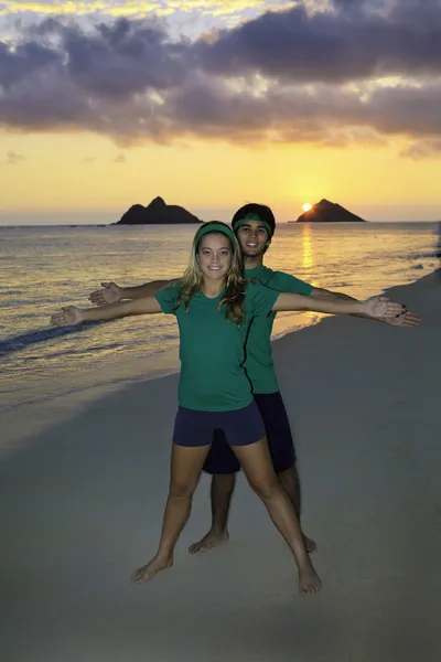Couple sur la plage faisant de l'exercice au lever du soleil — Photo