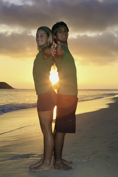Op het strand bij zonsopgang uitoefening (echt) paar — Stockfoto