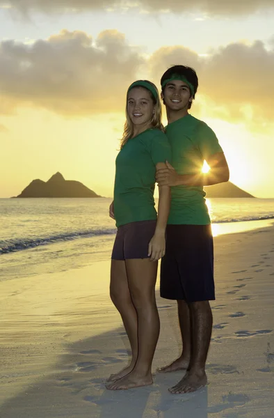 Couple on the beach exercising at sunrise — Stock Photo, Image