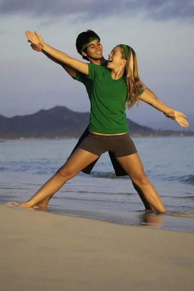 Пара на пляжі тренується на сході сонця — стокове фото
