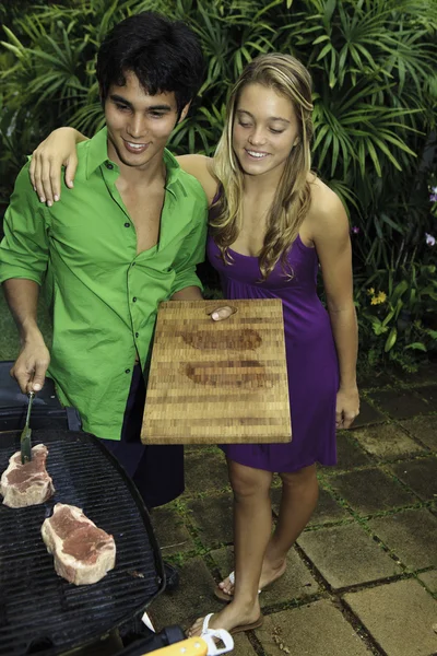 Casal fazendo um churrasco ao ar livre — Fotografia de Stock