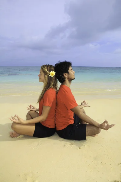 Paar meditiert am Strand — Stockfoto