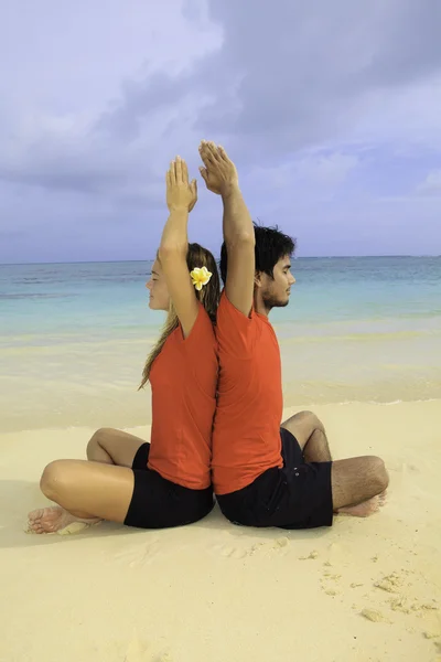 Paar mediteren op het strand — Stockfoto