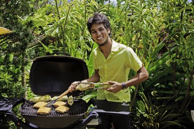 Adam mangal üzerinde hamburger yemek