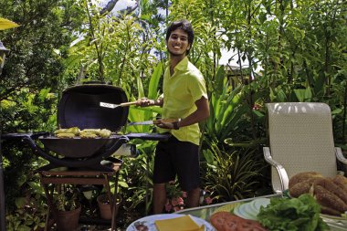 Adam mangal üzerinde hamburger yemek