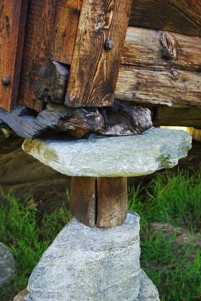 Angolo della casa, sostenuto da pietre e tronchi — Foto Stock
