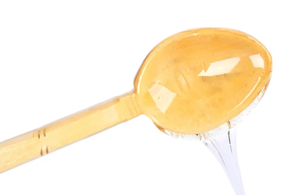 Honey dripping down the wooden spoon — Stock Photo, Image