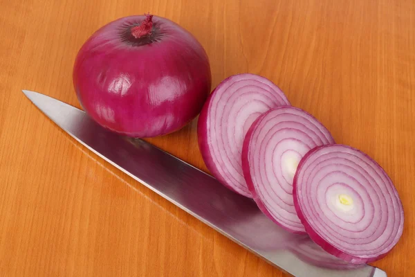 stock image Red onion, slices and knife on the kitchen board