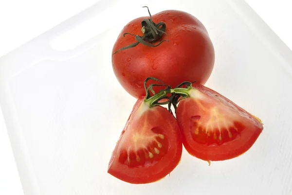 Cutting white plastic board with red tomato — Stock Photo, Image