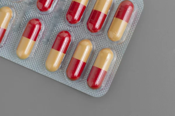 Blisterpackung Mit Gelben Und Roten Pillen Isoliert Auf Grauem Hintergrund — Stockfoto