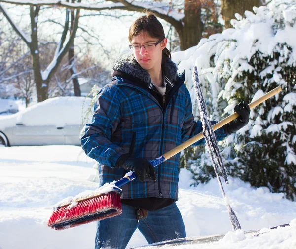 車から雪を取り除くプロセスにおいて若い男 — ストック写真