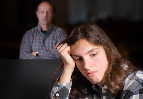 Een Onrustige Uitziende Tiener Met Zijn Vader Zoek Achtergrond — Stockfoto