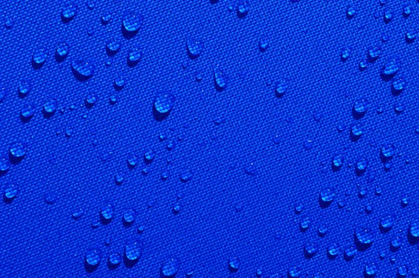 Gouttes d'eau sur tissu bleu — Photo