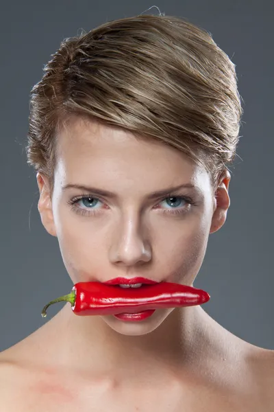 Woman biting chili pepper — Stock Photo, Image