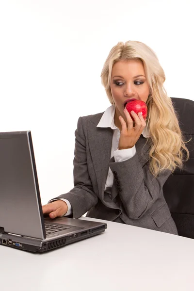 坐在一个桌子和早餐吃红苹果笔记本电脑性感商务女人肖像 — 图库照片