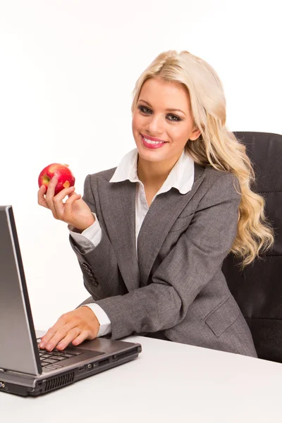 デスク ノート パソコン 朝食の赤いりんごを食べることによって座っているセクシー ビジネス女性の肖像画 — ストック写真
