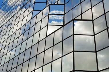 moderne glas kantoorgebouw met wolken en lucht reflecties.