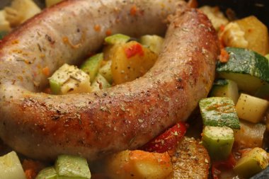 Baked sausage meat with vegetables and spices clipart