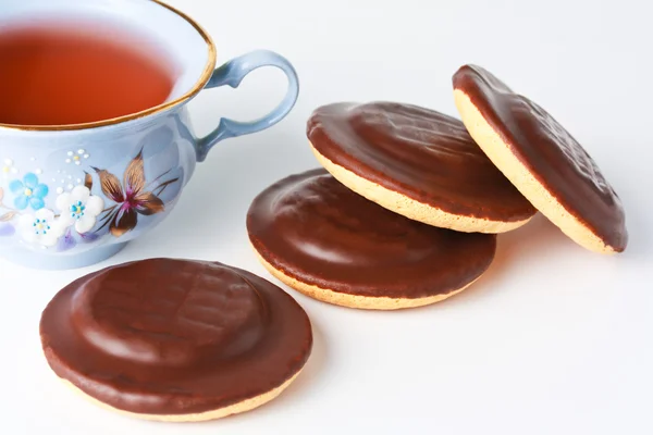 Cup of tea and chocolate iced cookies — Stock Photo, Image