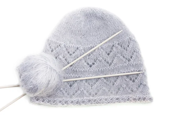 Grey woolen knitted mohair cap with clew and knitting needles — Stock Photo, Image