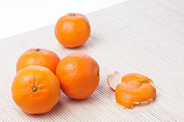 Pile of ripe fresh tangerines and piece of peel — Stock Photo, Image