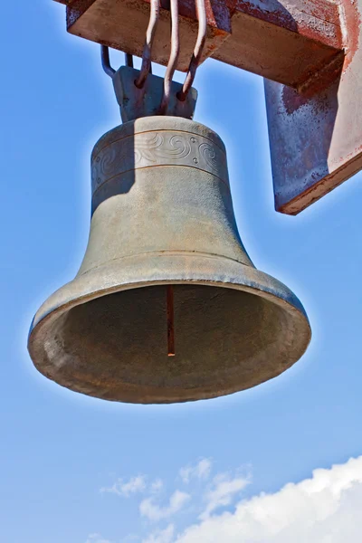 Выветрившийся чугунный колокол против голубого неба — стоковое фото