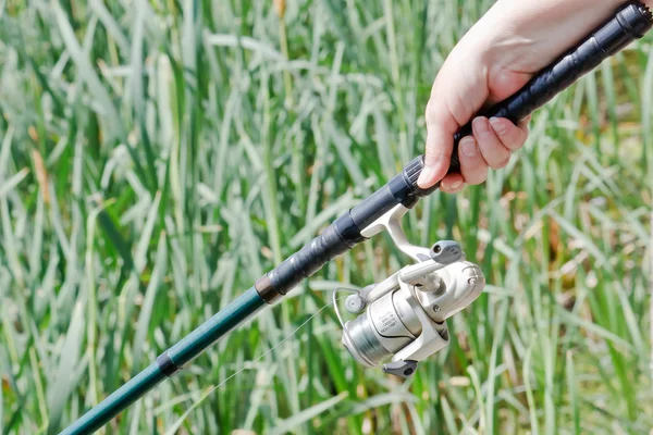 Pescadora mano sosteniendo una caña de pescar — Foto de Stock