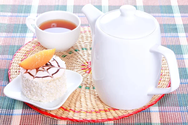 Milk jelly cake with peach and coconut decoration, teapot and a cup of tea — Stock Photo, Image
