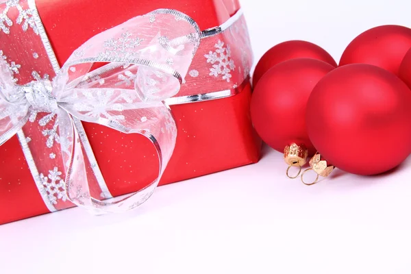 Christmas balls and a gift — Stock Photo, Image