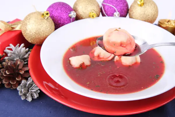 stock image Traditional polish Christmas Eve dish: clear borscht with uszka (a mushroom filled kind of dumplings) being eaten with a spoon and christmas decorations