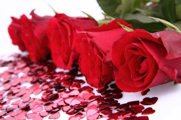 Červené růže a konfety — Stock fotografie