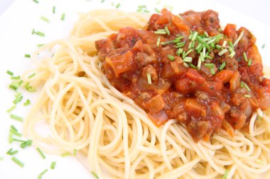 bir tabak spagetti bolognese bazı chives ile dekore edilmiştir.