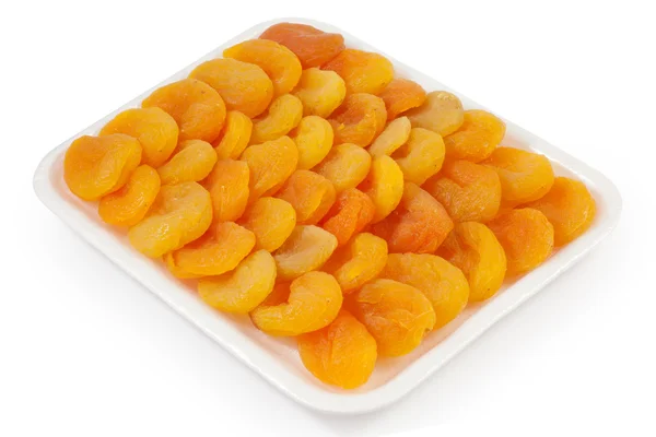 Torkade aprikoser på en vit platta — Stockfoto